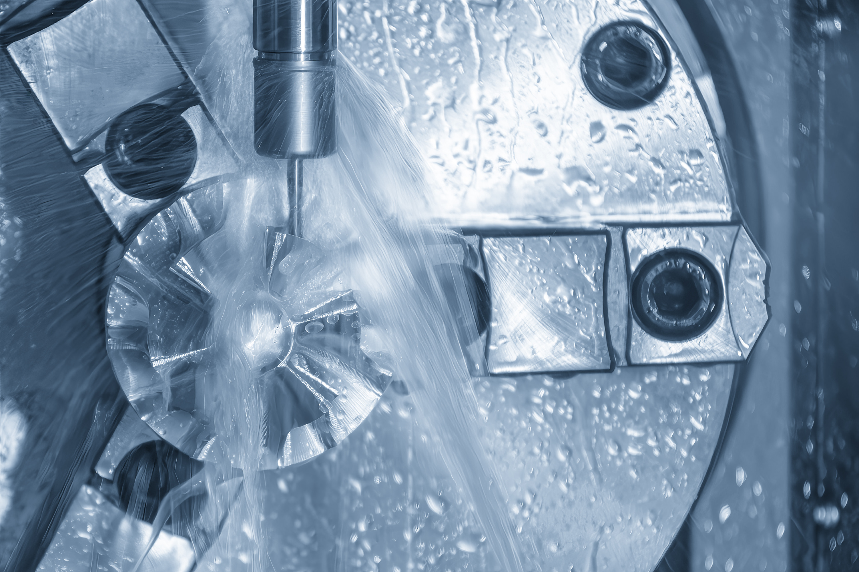 a CNC milling machine cutting a turbocharger automotive part with precision tooling and liquid coolant method